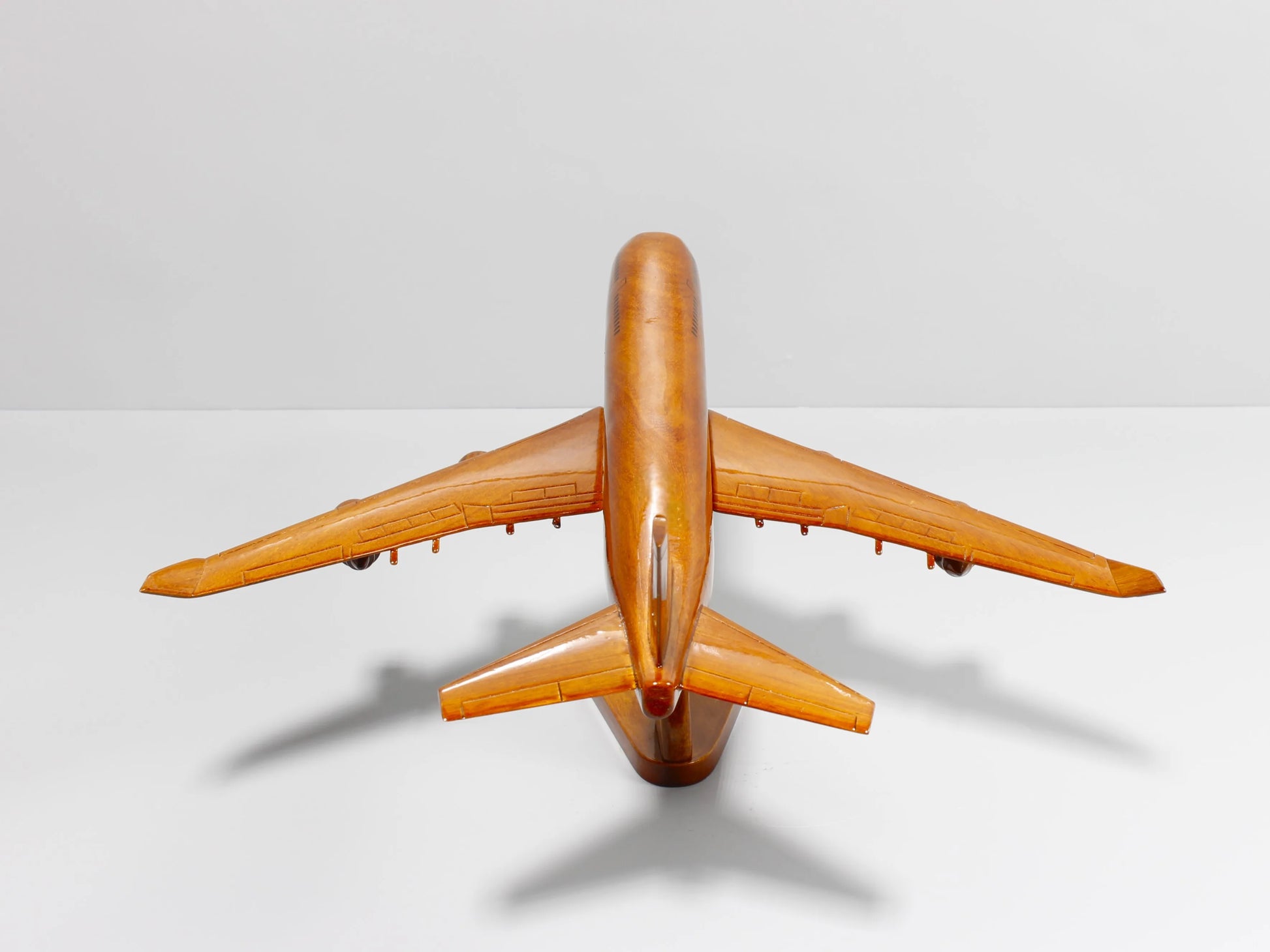 Top-down view of Boeing 747 handcrafted airplane model – wood grain detail