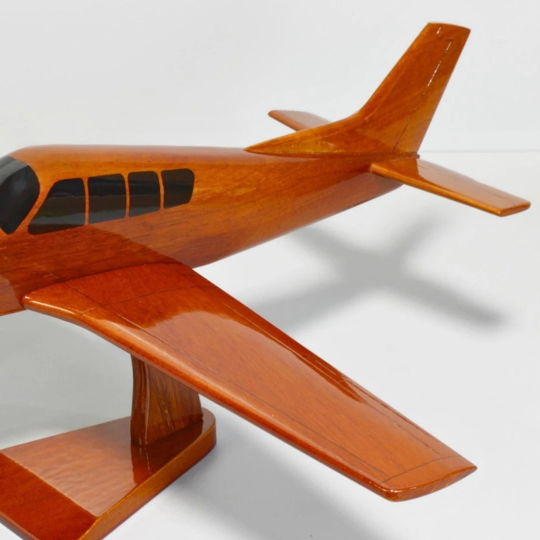 Close-up view of Beechcraft Bonanza Straight Tail wood model on mahogany stand – Premiumwoodart
