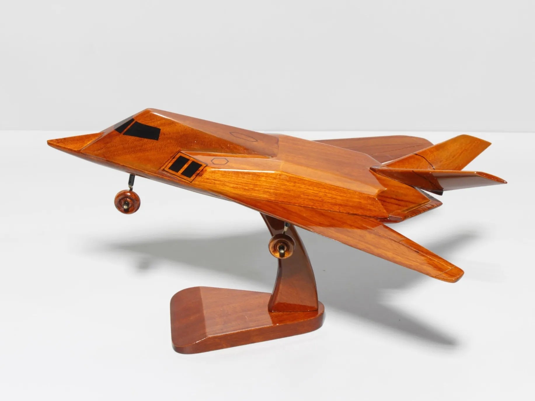 Side profile of handcrafted F-117 stealth jet wood model with polished finish