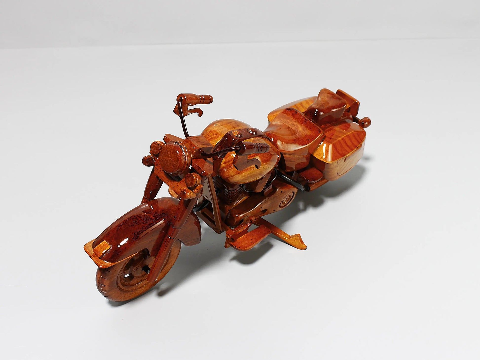 Front right angle showing handlebar and chrome-like features on wooden Harley model